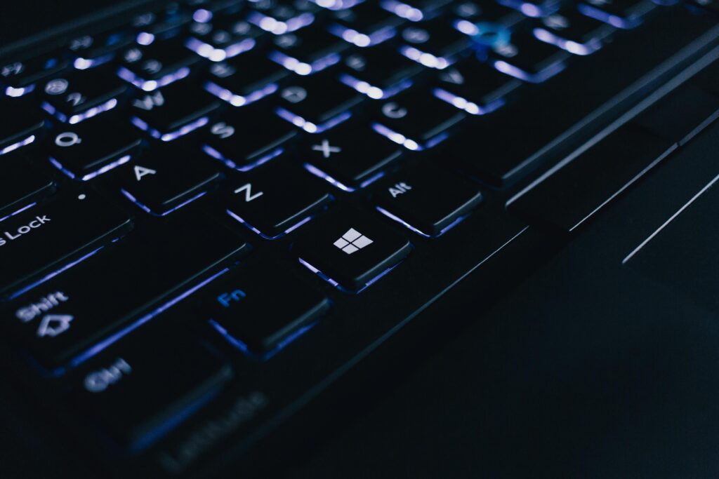 Detailed view of an illuminated laptop keyboard showing individual keys and backlight effect.