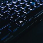Detailed view of an illuminated laptop keyboard showing individual keys and backlight effect.