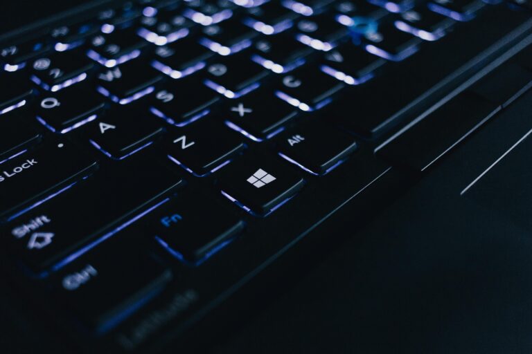 Detailed view of an illuminated laptop keyboard showing individual keys and backlight effect.